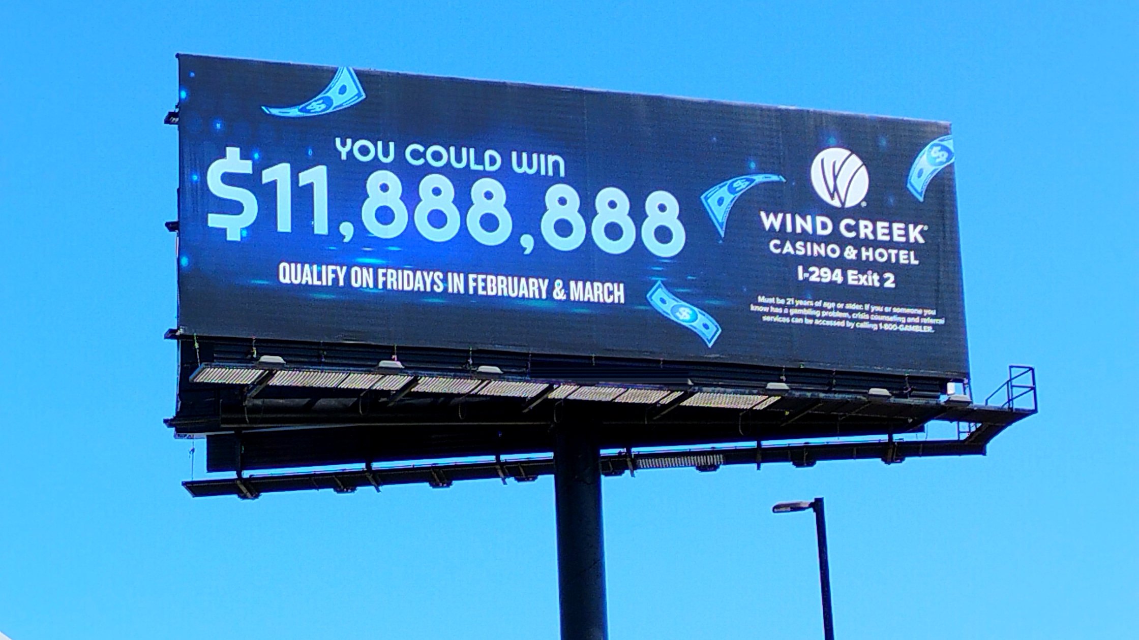 Billboard on a steel monopole against a clear blue sky